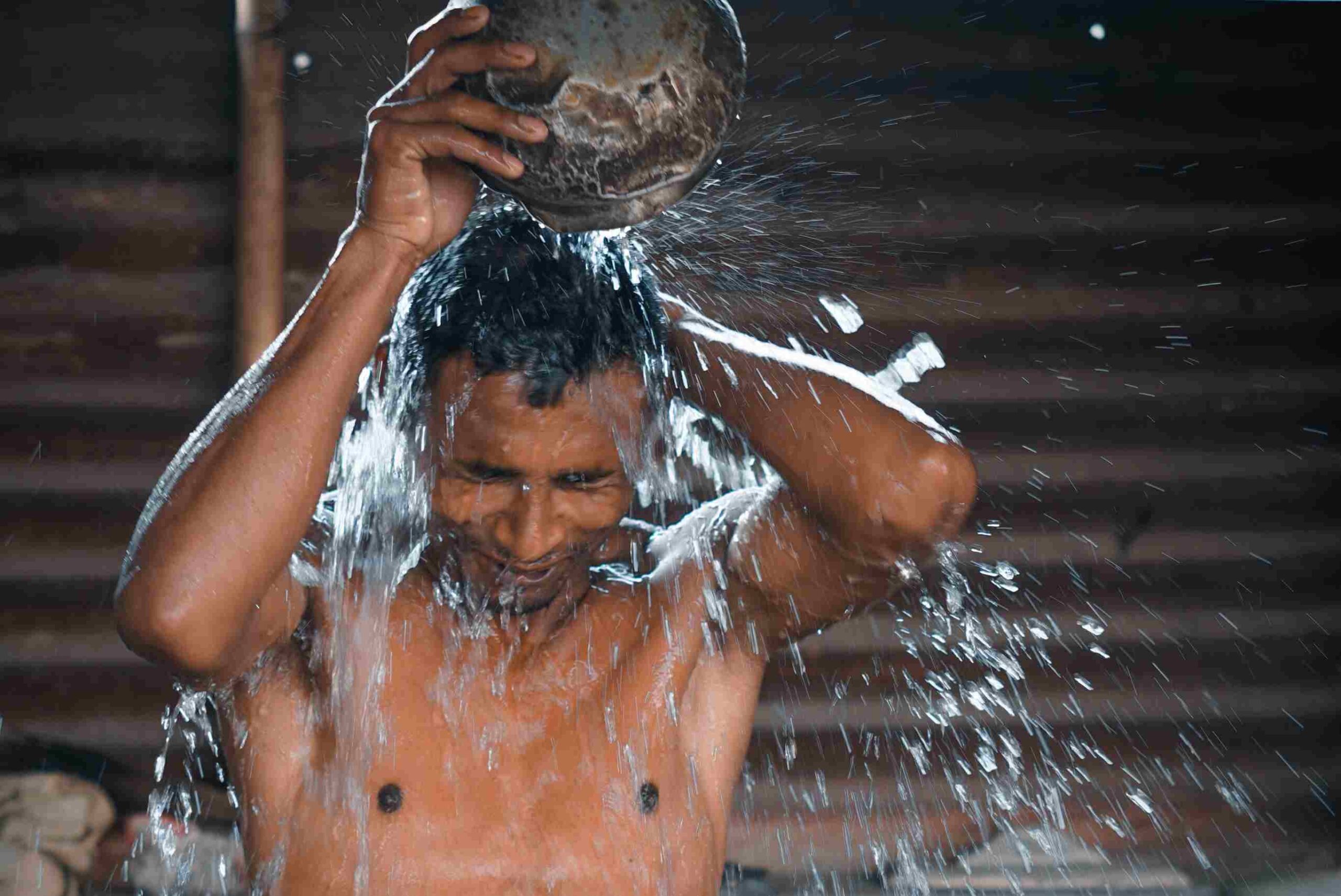 Mann gießt Wasser über Kopf